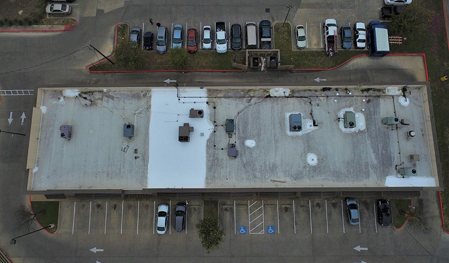 After: new white TPO membrane roof with corrected drainage on a North Austin retail building