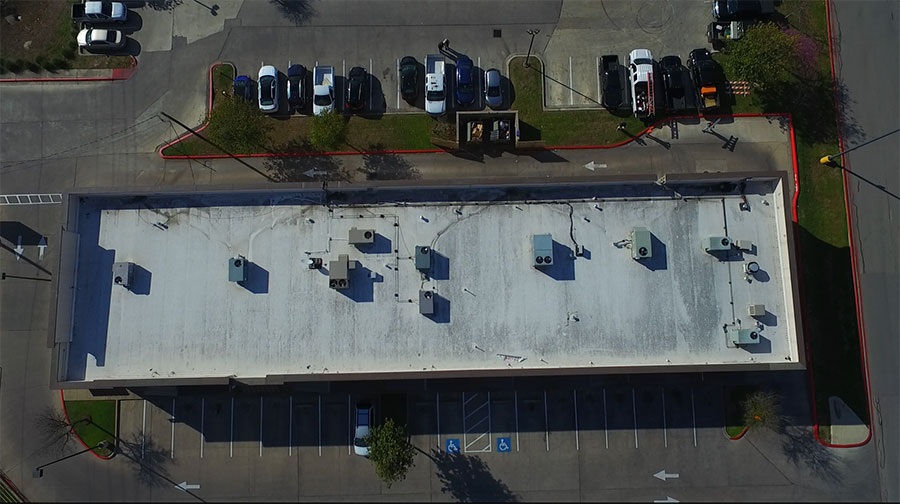 Before: ponding water on an aging modified bitumen commercial roof in North Austin