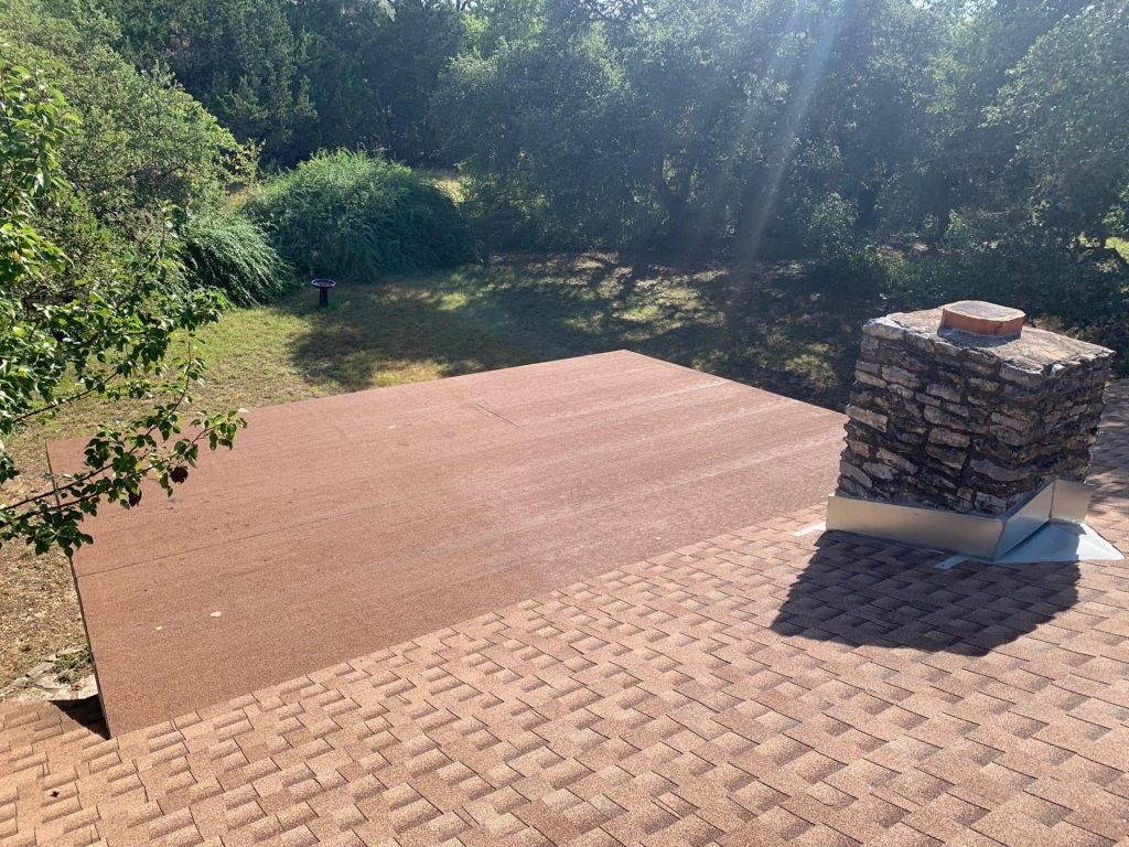 White TPO membrane flat roof on a modern Austin home with rooftop drains